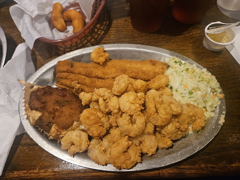 Plates of fried seafood on a simple table.